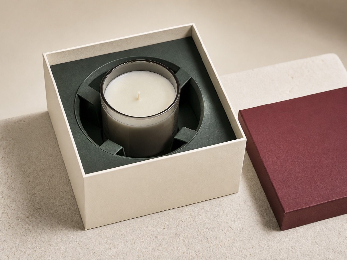 Blank smoke-glass candle held upright in a fitted forest-green paperboard cradle inside an ivory rigid box