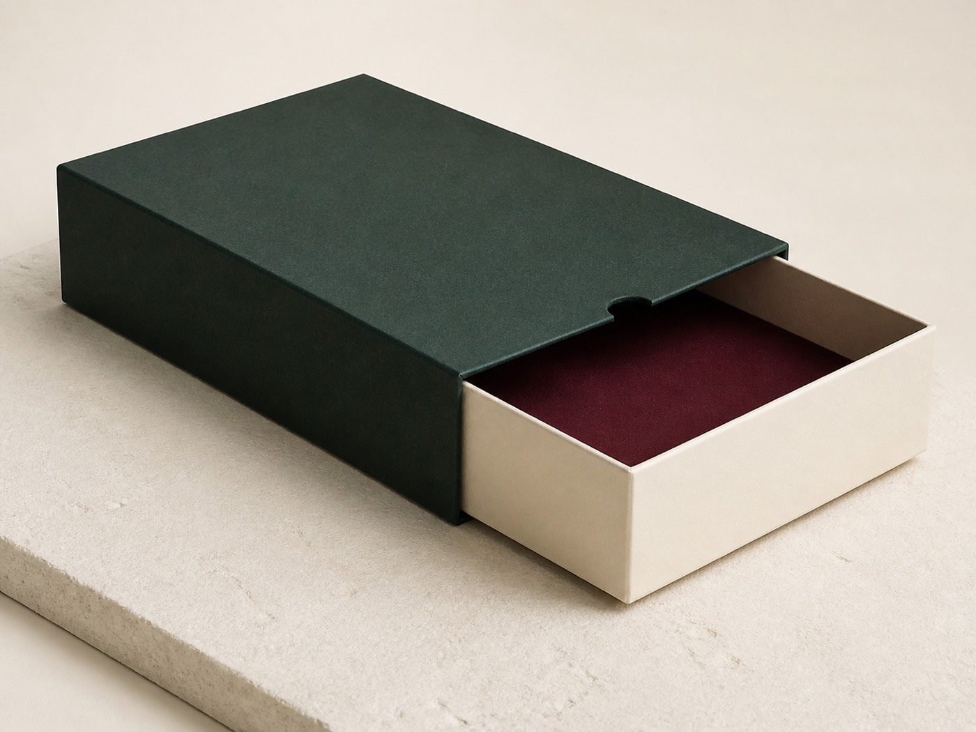 Ivory rigid tray part-open inside a forest-green sleeve with a thumb notch