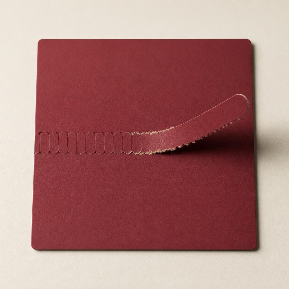 Approved tear-strip perforation detail on claret paperboard